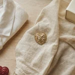 Broche coeur dorée sur tissu écru