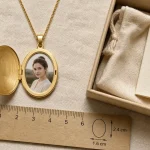 Collier medaillon doré : photo cachée, gravure et dimensions 2,4 x 1,6 cm