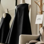 Robe trapèze femme noire coupe A midi, studio lumineux