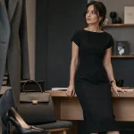 Robe noire droite chic mi-longue, bureau bois clair, accessoires gris et noir